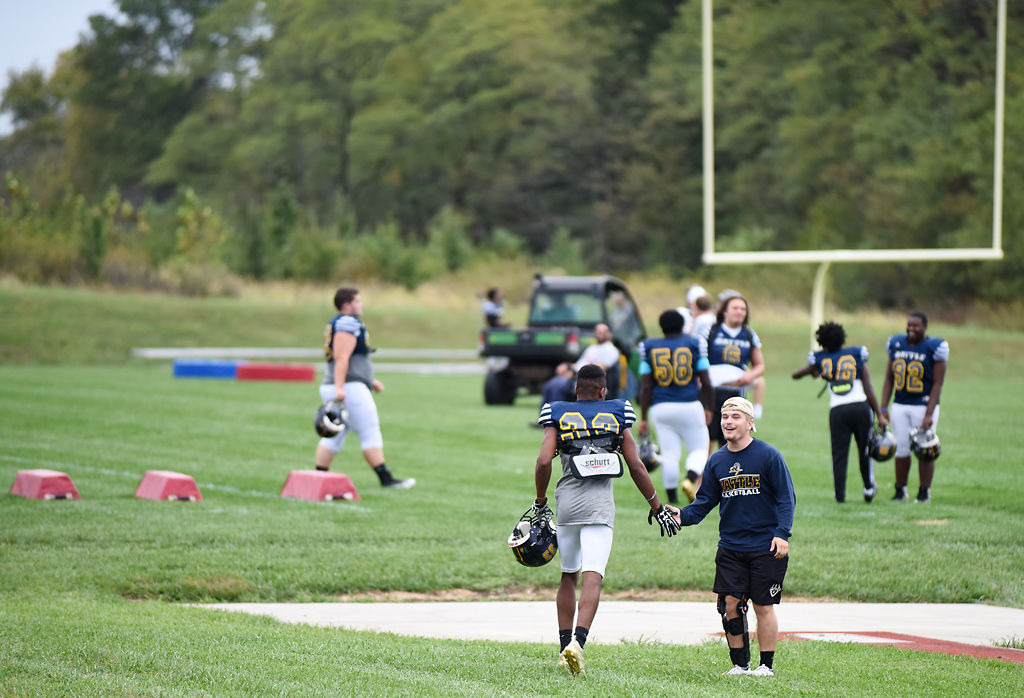 Cody Rachatellelle high fives Aaron Basden and the team